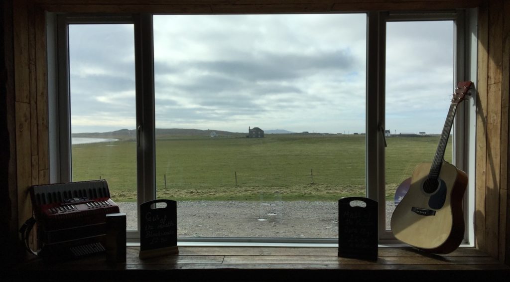 looking out through window across the machair towards the sea